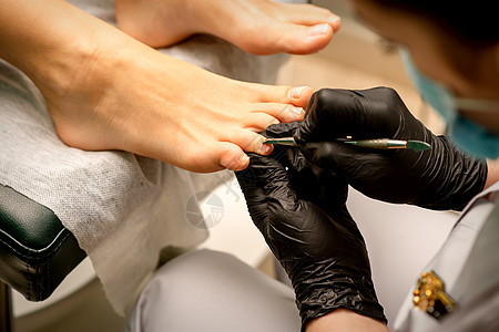 专业修脚术 在温泉沙龙切除女性脚趾的切片过程 美观的概念皮肤呵护病学医生关爱美甲卫生顾客手套趾甲图片
