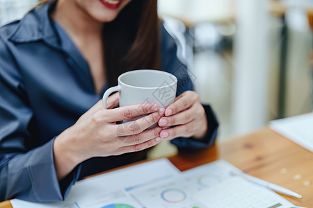 一个快乐的亚洲女人的肖像 白天咖啡休息时在她桌上微笑生意金发活动成人人士倾斜手机水平电脑咖啡杯图片