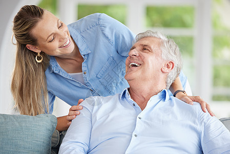 老人和女儿坐在家里的沙发上 开心 微笑 亲密无间 年迈的爸爸和女人在退休后有说有笑地度过时光 爱情 家庭和亲子关系图片
