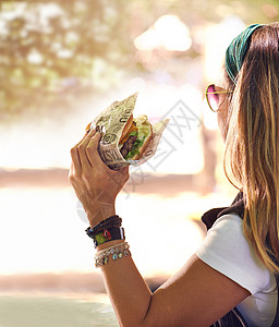 是时候吃点好吃的了 一个年轻女人在外面吃汉堡包图片
