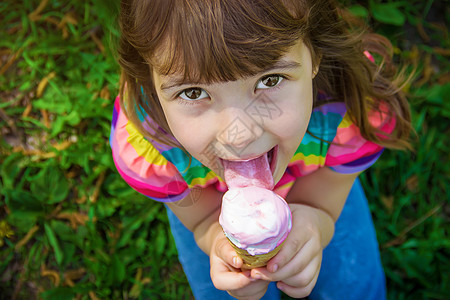 孩子吃冰淇淋 有选择的焦点舌头情绪圣代公园果汁女孩乐趣锥体甜点微笑图片