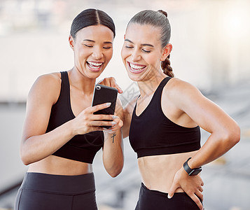在智能手机社交媒体应用程序上放松 运动的女性和朋友们在健身训练中休息一下 跨种族女孩友谊的乐趣 休闲和互联网娱乐一起锻炼休息图片