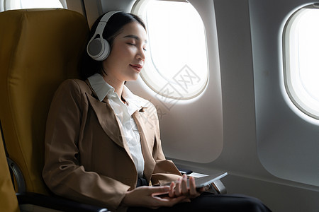 亚洲商业女商务人士在飞机上睡觉 而飞行去见客户图片