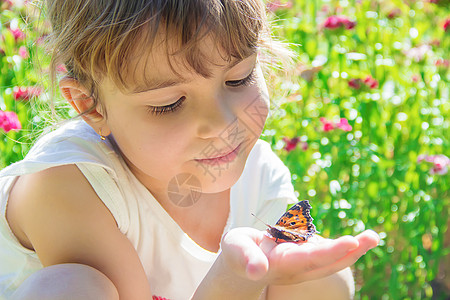 玩蝴蝶的女孩一只蝴蝶的孩子 有选择的焦点橙子工作环境木板花朵游戏墙纸婴儿魔法昆虫背景