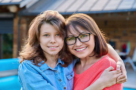 快乐的母亲和少女女儿的肖像 看着镜头父母女性乐趣童年女士快乐孩子女孩拥抱青少年图片