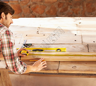 让他的测量恰到好处 一名勤杂工使用水平仪和卷尺进行完美的测量建设者男人工匠工作成人建筑精神木头维修木制品图片