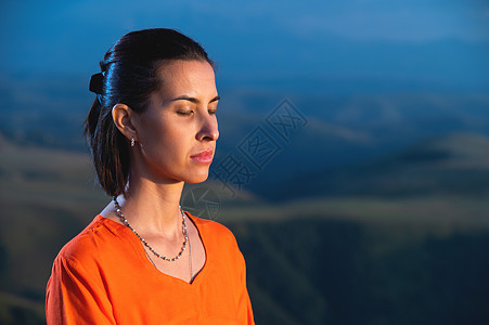 美丽的梦幻女美人 闭着眼睛在户外冥想 暗绿色自然背景的模糊影响 特写图片