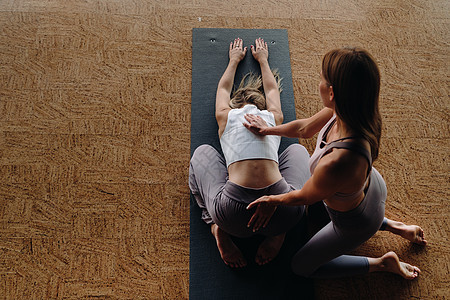 瑜伽练习 一名个人教练在健身房教妇女瑜伽课程班级成人帮助节目运动姿势朋友活力性别活动图片