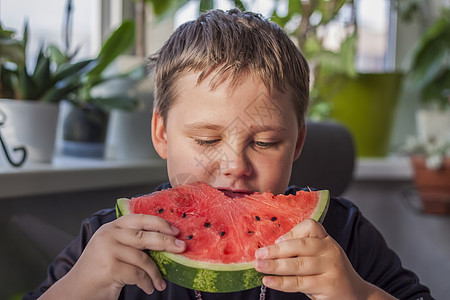 可爱的男孩在家里吃西瓜 不摆姿势就真实的情感红色季节性男生男人喜悦甜点童年食物生长水果图片