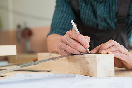 木匠测量木板 在车间用铅笔作记号标记工作木头工作台木工男人修理工工具家具建设者男性图片