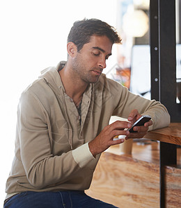 还等着 一位英俊的年轻人 在咖啡馆里坐着看短信图片