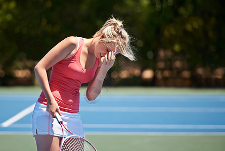 一个网球运动员拿着网球拍打时 把她的头放在她手上的手里 真是令人沮丧图片
