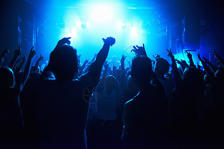 一群观众在夜总会的舞台上看乐队剧 他们聚集一堂音乐会青年乐趣展示俱乐部音乐居住享受手势娱乐乐队图片