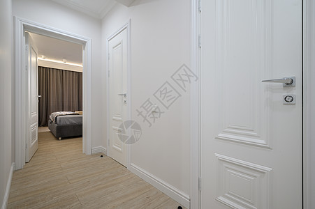 白色走廊与有门的卧室相连图片