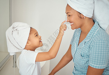 浴室里的母亲 面霜和女童在早上洗澡时使用美容 化妆品和乳液产品 幸福 微笑或快乐的妈妈和小孩喜欢护肤霜 在家粘合图片
