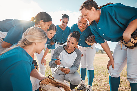 女子垒球队教练 在比赛或比赛前与球员一起计划 女棒球队教练挤在一起 谈论团队合作和战略 赢得体育比赛或奖杯的动机图片