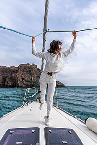 夏日banner女人站在游艇的鼻子上 在阳光明媚的夏日 微风长着头发 美丽的海在背景上女性闲暇乐趣享受巡航魅力女士派对海滩旅游背景