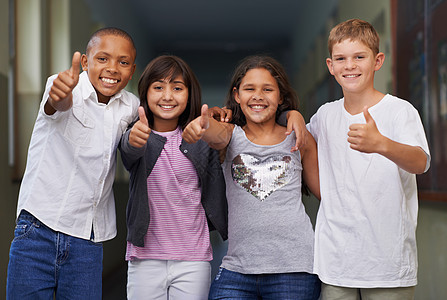 朋友让学校充满乐趣 四个朋友手挽手站在他们学校的走廊上 对你竖起大拇指图片