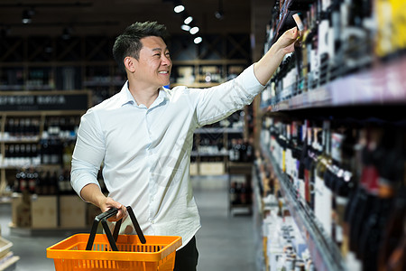 韩国超市年轻亚洲男商务人士在超市的酒厅里 选酒馆里的葡萄酒背景
