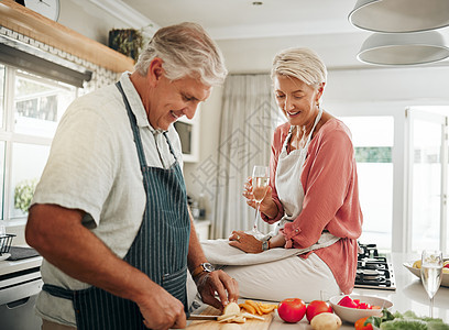 爱 食物和老年夫妇正在厨房里一起做健康的晚餐 在家里享用葡萄酒和亲近 微笑 节食和素食老人帮助已婚老年妇女切菜图片