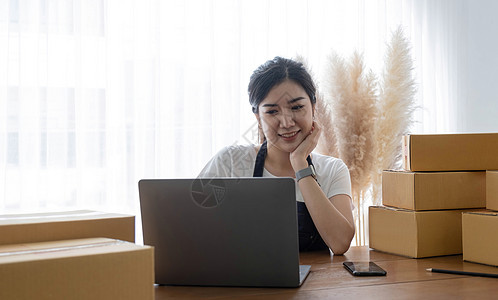 创业小企业自由职业者 在家办公室工作的肖像年轻女性 BOX 智能手机 笔记本电脑 在线 营销 包装 交付 中小企业 电子商务概念图片