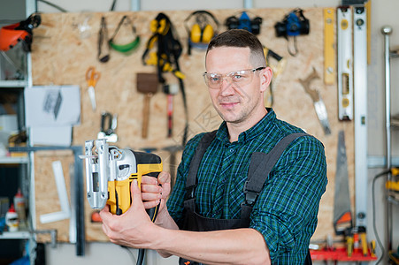 一名男子在车间用电锯锯木头的肖像工匠机器拼图硬木工作作坊职场修理工工艺手工图片