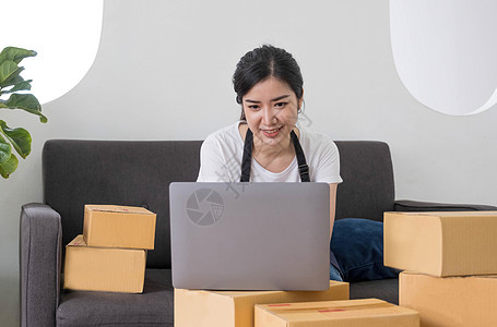 创业小企业自由职业者 在家办公室工作的肖像年轻女性 BOX 智能手机 笔记本电脑 在线 营销 包装 交付 中小企业 电子商务概念图片