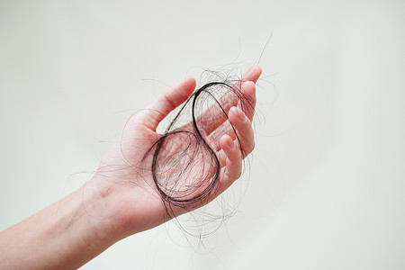 亚裔妇女手上的长发夹带有问题女性外貌化妆品保健头发刷子展示诊所梳子手指图片