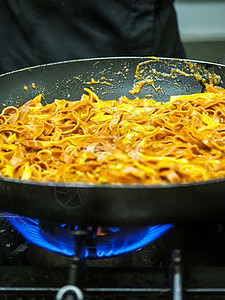 烹饪厨师将美味的意大利意大利意大利意粉和餐厅蘑菇酱混合在一起饮食火焰商业工作职业健康饮食面团油炸人手火炉图片