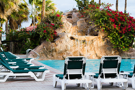 游泳池热带酒店叶子假期游客棕榈液体瀑布椅子植物科图片