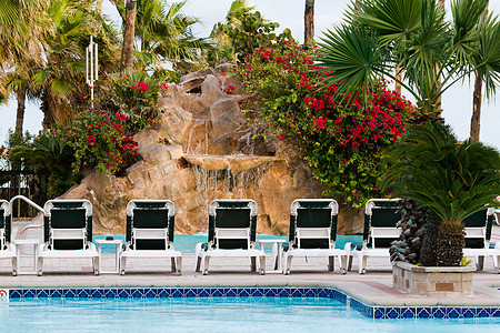 游泳池假期棕榈旅行泳池岩石瀑布叶子椅子液体躺椅图片