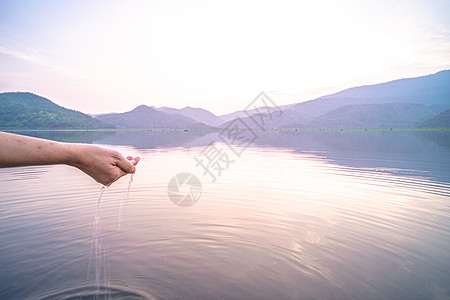 妇女利用自然湖山地背景亲手取清水处理卫生人手太阳自然资源环境反射荒野生态蓝色图片