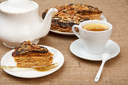 一杯茶 瓷茶壶和白盘上自制巧克力泡芙蛋糕厨房饼干食物饮料馅饼麻布白色盘子早餐糕点图片