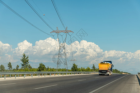一辆卡车在高速公路上行驶 一条高压电线在公路一侧图片
