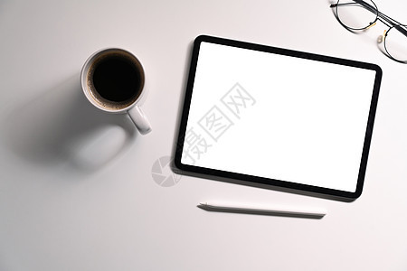 白色背景上带有空显示器 咖啡杯和眼镜的平面平板数字平板图片