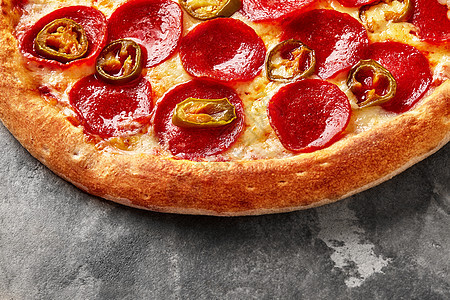 灰石上带熔化的马扎里拉 番茄酱 辣椒尼和墨西哥面条的披萨图片