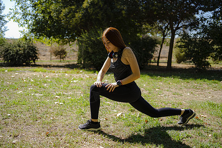 红头健身妇女为腿肌肉训练做肺锻炼运动灰色姿势活力女孩女性力量健身房女士运动装图片