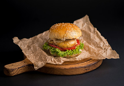 深色背景中质朴的木板上放着生菜 奶酪 洋葱和番茄的美味新鲜自制汉堡的特写小吃沙拉午餐芝麻黑色食物面包美食包子汉堡图片