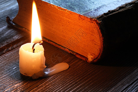 贴近书的蜡烛燃烧灯芯宗教火焰悲哀悲伤智慧上帝知识阅读图片