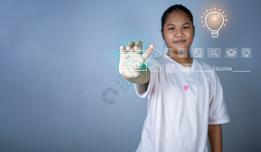 教育概念图片 一个女孩站着 手里拿着一个代表创造力和创新的教育图标 教育信息搜索指南 复制空间图片