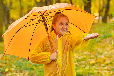 在秋天公园 快乐的小孩 被雨滴落到秋天公园花园下雨女孩公园孩子彩虹喜悦水坑雨衣乐趣图片