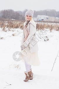 一个穿着冬装的金发女孩 走在白雪皑皑的草原上 冬天在雪地里穿着浅色衣服微笑的女人女士色调暖手毛衣皮衣暴风雪草原手套雪地靴外套图片