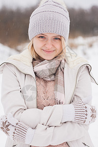 一个穿着冬装的金发女孩 走在白雪皑皑的草原上 冬天在雪地里穿着浅色衣服微笑的女人羊毛外套季节手套雪地靴围巾暴风雪女士草原裙子图片