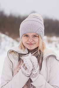 一个穿着冬装的金发女孩 走在白雪皑皑的草原上 冬天在雪地里穿着浅色衣服微笑的女人女士毛衣色调围巾手套季节大衣暴风雪毛皮帽子图片