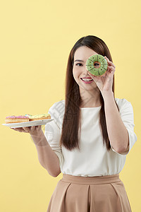 有魅力的女孩拿着新鲜甜甜圈 享受甜食的乐趣 心情好 饮食概念盘子蓝色女性蛋糕食物白色图片