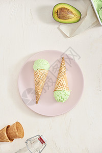 白色背景的圆锥形冰淇淋小松饼中绿色鳄梨冰淇淋勺 copy space薄荷食物甜点冰淇淋奶油状开心果图片