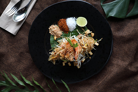 泰国食用棉面条和虾鱼午餐油炸面条蔬菜豆腐花生柠檬盘子菜单美食图片