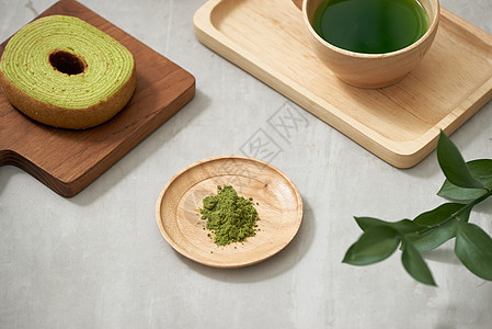 一个木杯中的绿茶红茶 和德国蛋糕放在棕色垫子上甜点圆形桌子美食白色食物绿色小吃抹茶粉色图片