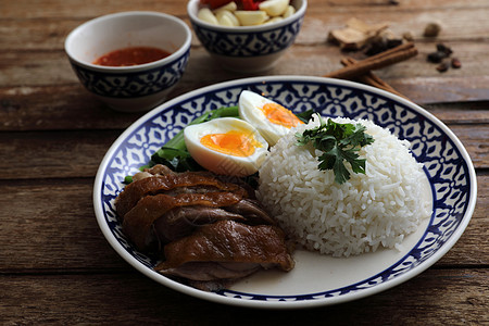当地泰国食品在木本背景中孤立的米饭上煮猪肉腿盘子文化食物美食街道午餐图片