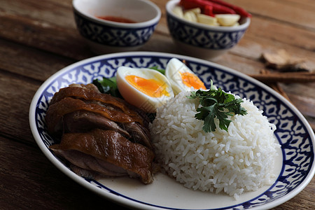 当地泰国食品在木本背景中孤立的米饭上煮猪肉腿盘子食物文化街道午餐美食图片